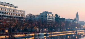 Kesäinen Turun jokiranta illalla auringonlaskun aikaan, taustalla kerrostaloja.